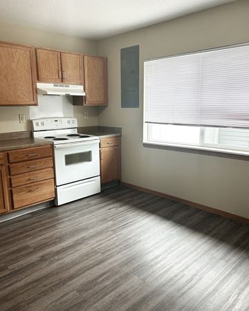 Litchfield townhouse for rent - A kitchen with a white stove top oven and wooden cabinets.