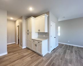 Mankato townhouse for rent - an empty kitchen with white cabinets and a wood floor
