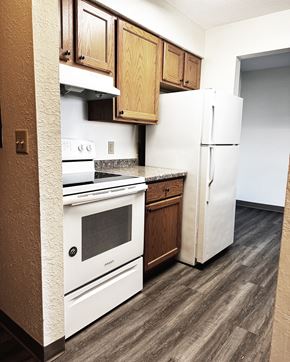 Willmar And  Alexandria apartment for rent - A kitchen with white appliances and wooden cabinets.
