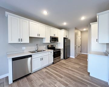 Mankato townhouse for rent - a kitchen with white cabinets and stainless steel appliances