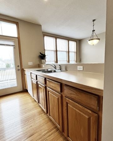 Faribault townhouse for rent - A kitchen with wooden cabinets and a white countertop.
