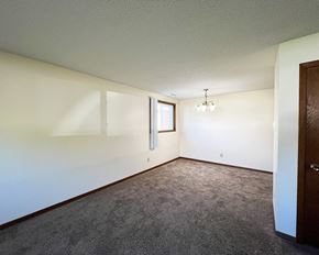 North Mankato apartment for rent - an empty living room with white walls and carpet