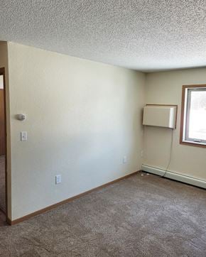 Northfield apartment for rent - an empty living room with a heater and a window