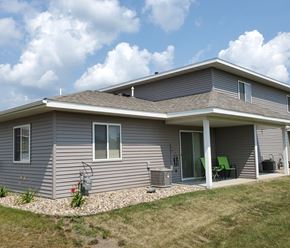 Northfield townhouse for rent - A house with a grey siding and a green chair on the porch.