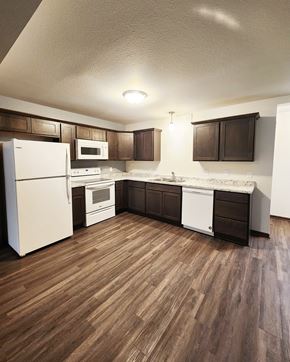 Northfield townhouse for rent - A kitchen with white appliances and brown cabinets.