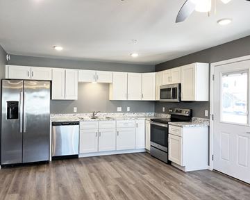 Mankato townhouse for rent - A kitchen with white cabinets and a wooden floor.