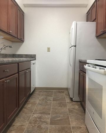 North Mankato townhouse for rent - A kitchen with brown cabinets and a white refrigerator.