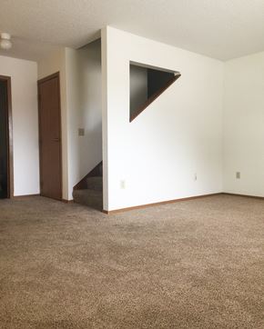 North Mankato townhouse for rent - A room with a carpeted floor and a stairway leading to the second floor.