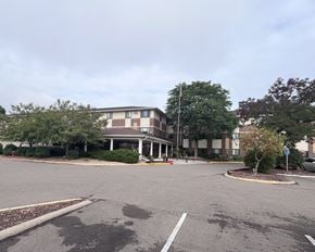 Hastings apartment for rent - A parking lot in front of a building with a flag pole.