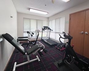 Hastings apartment for rent - A gym room with a treadmill, a stationary bike, and a bench press.