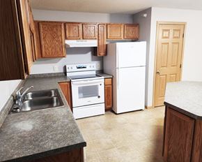 Worthington apartment for rent - A kitchen with a white refrigerator, white oven, and white microwave.