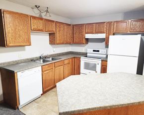 Worthington apartment for rent - A kitchen with wooden cabinets and white appliances.