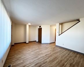 Sleepy Eye apartment for rent - A room with wooden flooring and white walls.