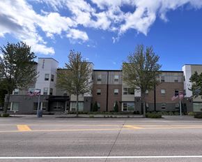 Ramsey apartment for rent - A building with a grey and white facade and a flag on the left side.