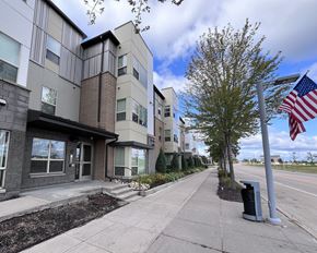 Ramsey apartment for rent - A street view of a residential area with apartment buildings and an American flag.