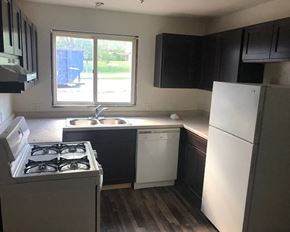 St. Peter apartment for rent - an empty kitchen with black cabinets and white appliances