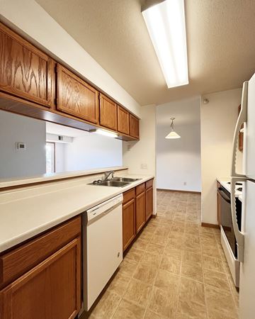 Pine Island apartment for rent - A kitchen with wooden cabinets and white appliances.