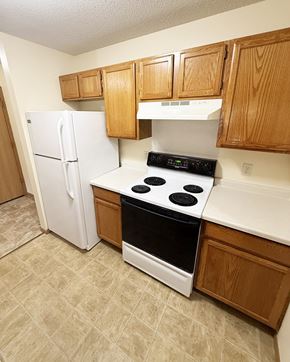 Pine Island apartment for rent - A kitchen with a white refrigerator, white stove, and wooden cabinets.