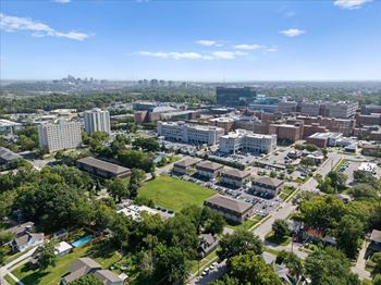 A cityscape with buildings and greenery under a clear sky.