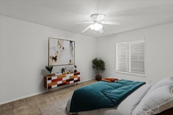 A bedroom with a bed and a ceiling fan
