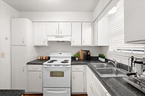 Overland Park townhouse for rent - a kitchen with white appliances and white cabinets at Sheridan Ridge Townhomes Apartments, Kansas, 66212