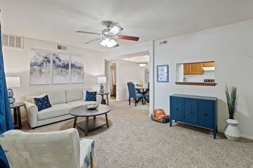 Overland Park apartment for rent - the living room and dining room of an apartment with furniture and a ceiling fan