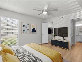 Overland Park apartment for rent - a bedroom with a bed and a tv at Highland Park Apartment Homes, Overland Park