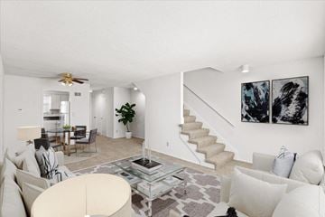 Overland Park townhouse for rent - a living room with couches and a table and a staircase