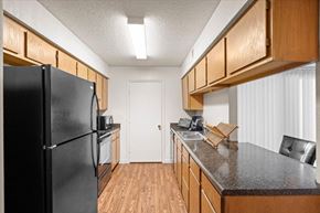 Lenexa apartment for rent - a kitchen with a black refrigerator and a counter top at Wind River Lodge, Lenexa