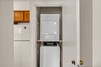 A white washing machine is in a small laundry room.