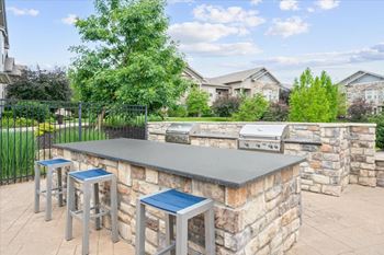 A barbecue grill is on a stone patio.