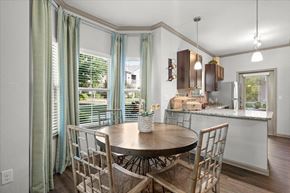Overland Park apartment for rent - a dining room with a table and chairs and a kitchen in the background at Stonepost Crossing Apartments, Overland Park, KS, 66213