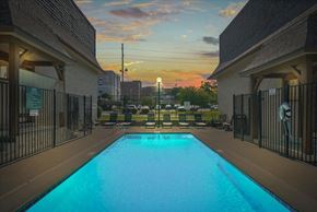 Kansas City apartment for rent - A swimming pool surrounded by a fence and buildings. at Malvern Hill Apartment Homes, 66103, Kansas