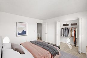 Overland Park townhouse for rent - a bedroom with a bed and a closet at Sheridan Ridge Townhomes Apartments, Overland Park