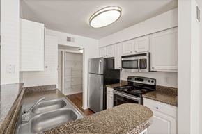Overland Park apartment for rent - a kitchen with granite countertops and white cabinetsat Stonebriar Woods Apartments, Kansas, 66213