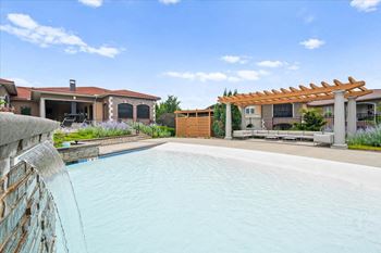 A large swimming pool with a house in the background