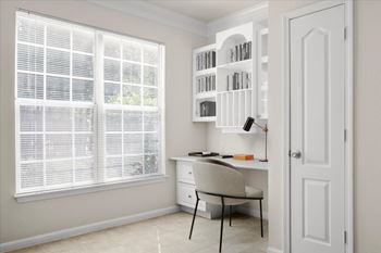 A room with a desk, chair, and bookshelf.