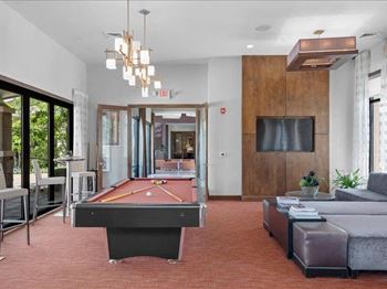 A living room with a pool table and a tv