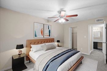 A bedroom with a bed and a ceiling fan