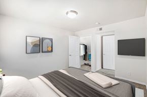 Overland Park apartment for rent - a bedroom with a large bed and a television on the wall at Stonebriar Woods, Overland Park