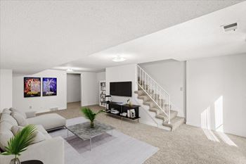 A living room with a staircase and a television.