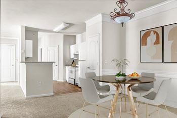 A dining room with a table set for two and a chandelier hanging from the ceiling.