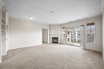 A spacious living room with a fireplace and sliding glass doors.