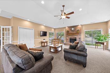 A living room with a grey couch and a fireplace.