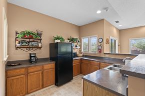Overland Park apartment for rent - A kitchen with a black refrigerator and wooden cabinets at Coventry Oaks Apartments, Overland Park, KS