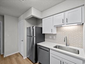 Overland Park apartment for rent - a kitchen with white cabinets and a stainless steel refrigerator at Highland Park Apartment Homes, Overland Park