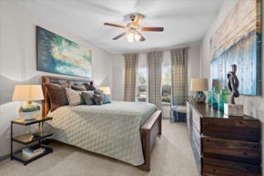 Overland Park apartment for rent - a bedroom with a bed and a ceiling fan at Stonepost Crossing Apartments, Kansas