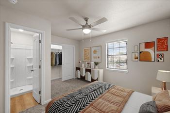 A bedroom with a large bed and a ceiling fan.