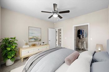 A bedroom with a bed and a ceiling fan