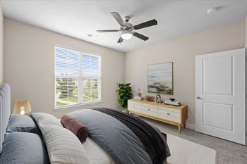 A bedroom with a bed and a ceiling fan